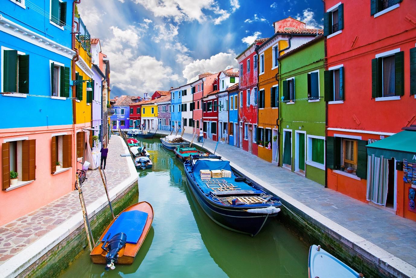 Venice, Burano island canal, small colored houses and the boats