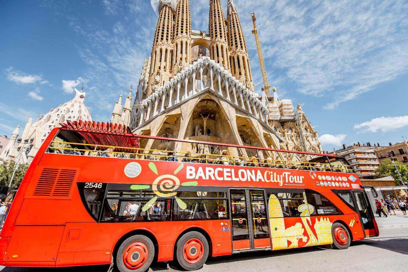 Tourist bus near the famous Sagrada Familia roman catholic church in Barcelona, Spain, designed by catalan architect Antoni Gaudi.